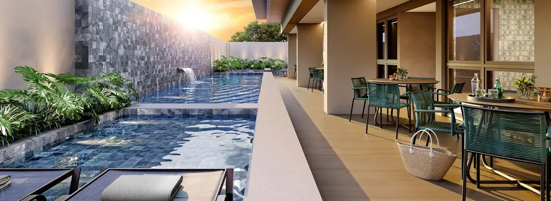 Piscina do Dom Park Residencial com cascata, deck molhado e mesas no deck ao pôr do sol